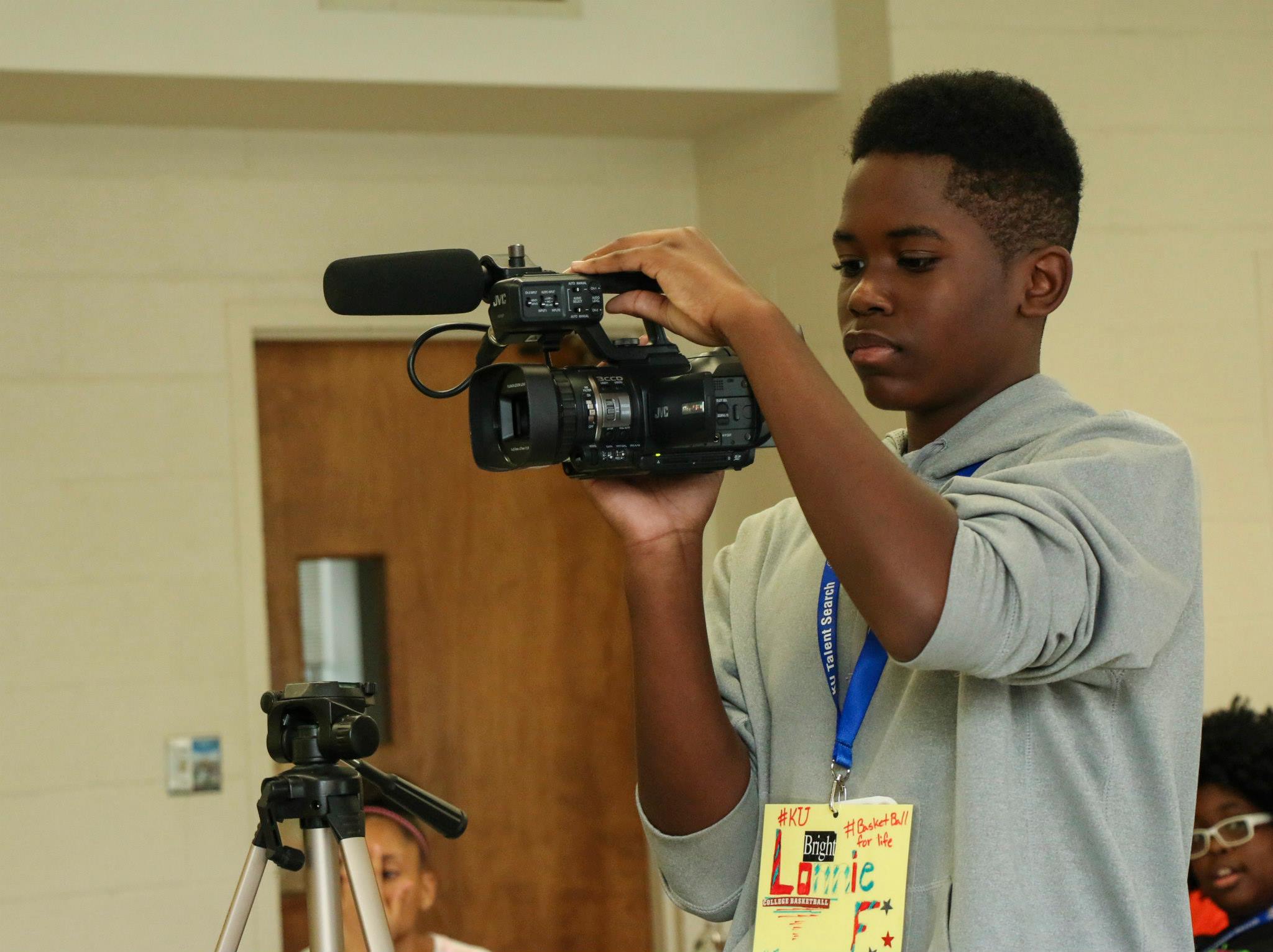 A Black male student holding a video camera