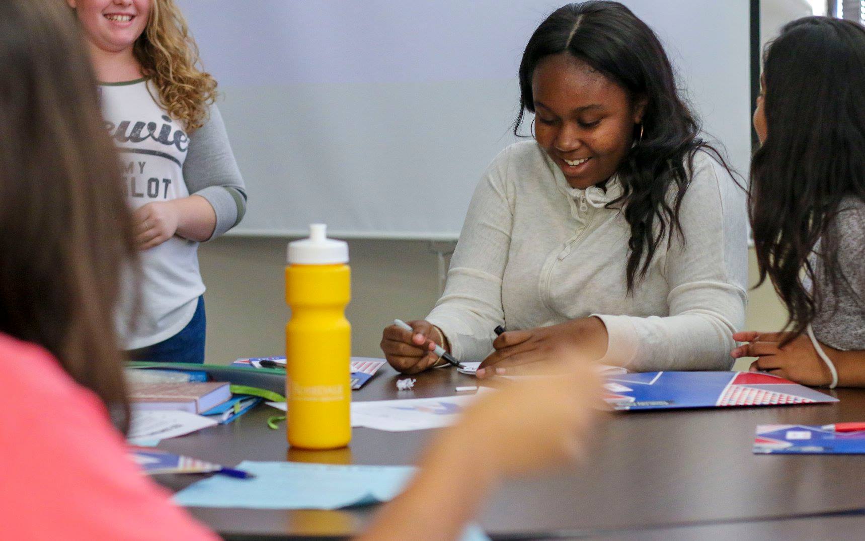 A Black female student sitting at a table in a workshop